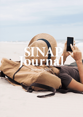 表紙 SINAP Journal Summer 2017 リュックを枕に砂浜に仰向けに寝そべった女性がスマートフォンを操作している